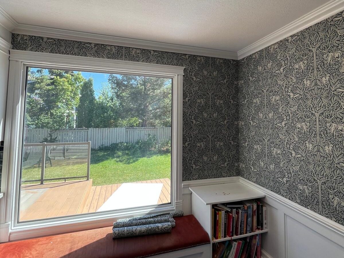 Blue botanical wallpaper installed around a dining room window in Deer Run SE Calgary