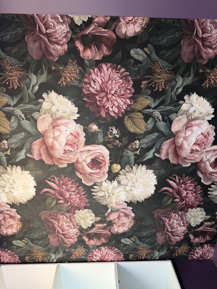 Detail of blush peony and chrysanthemum mural wallpaper on a near-black ground in Canmore