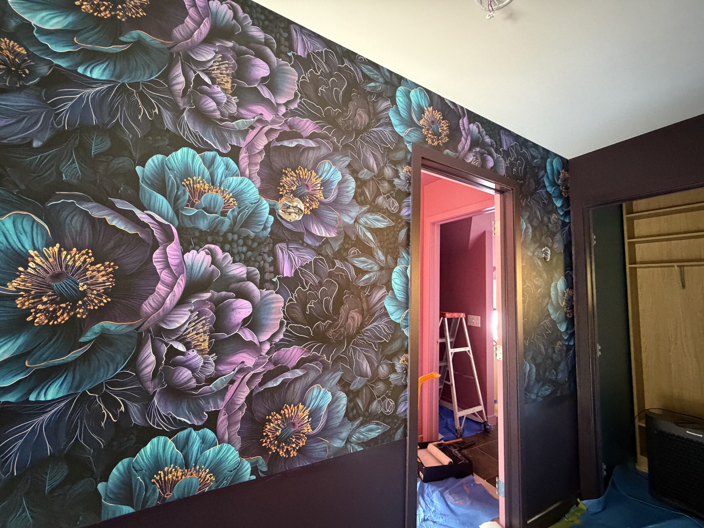 Teal and violet peony mural wallpaper with gold linework around a bedroom doorway in Canmore, AB