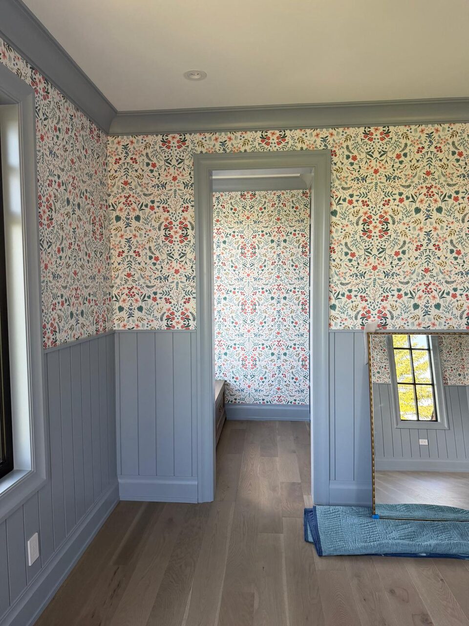 Wildflower wallpaper carried around a cased doorway and continuing into an adjoining nook with a window seat in Elbow Valley