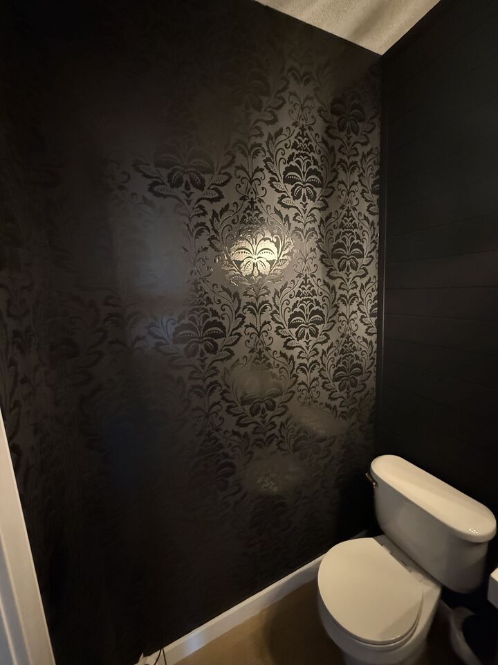 Finished black damask wallpaper repair in a Heritage Pointe powder room