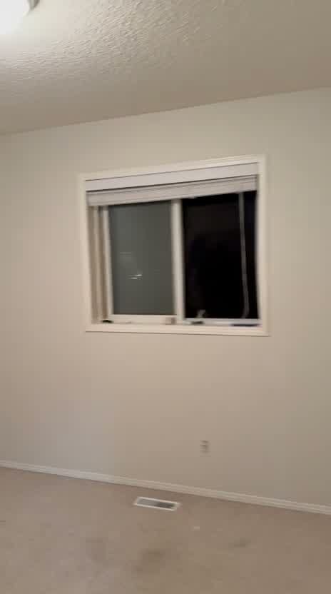 Bedroom window wall restored to smooth painted finish after wallpaper removal in Inverness, McKenzie Towne, SE Calgary