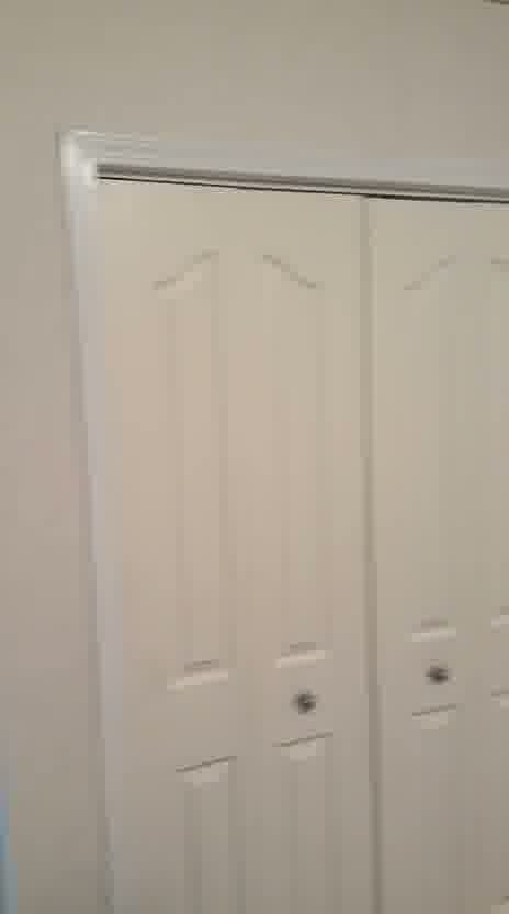 Smooth repainted wall beside closet doors after wallpaper stripping in a McKenzie Towne, Calgary bedroom