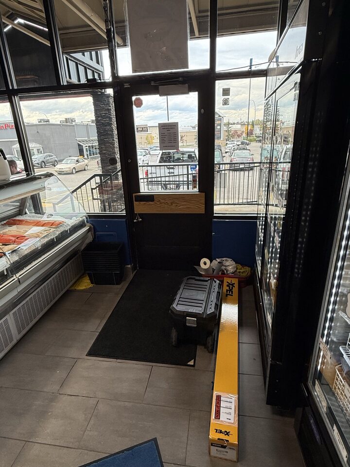 Entry door and adjacent fish market display glazing prepared with commercial solar-control window film in NW Calgary