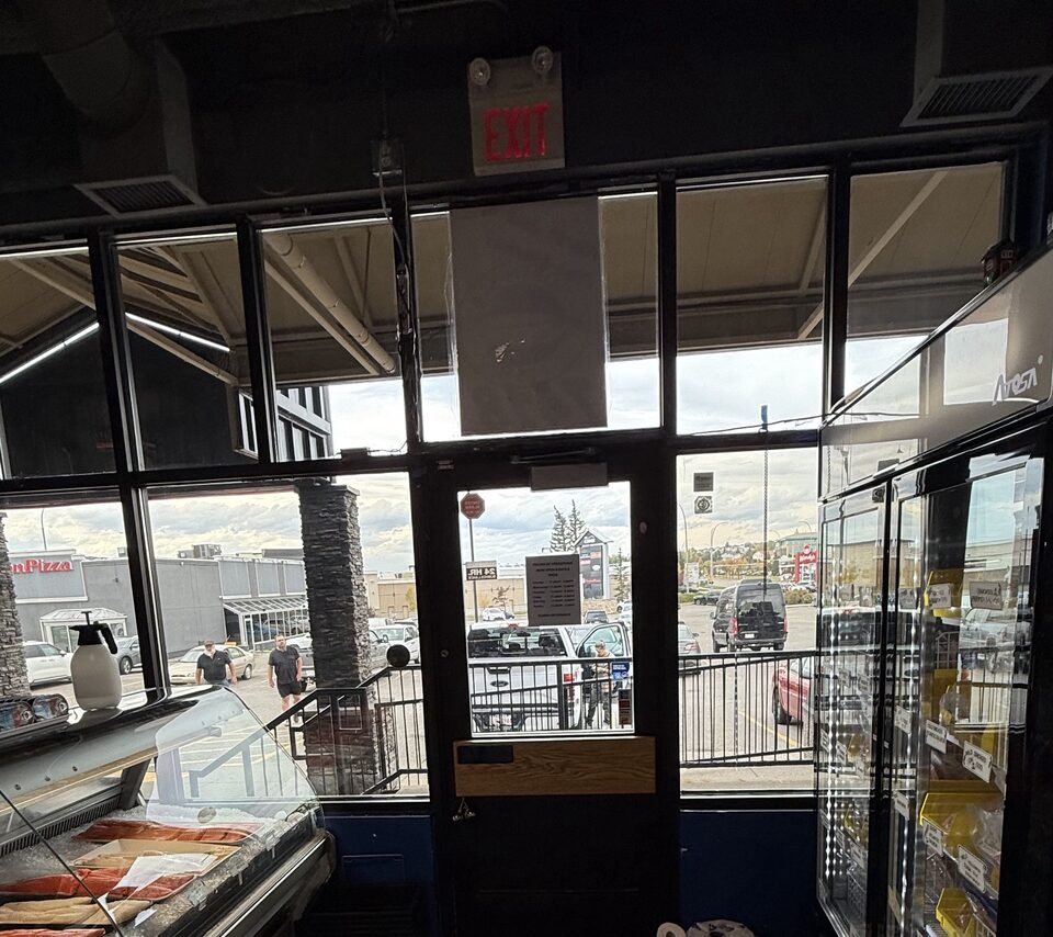 Front glass and entry door with commercial solar-control window film at North Sea Fish Market Crowfoot in Arbour Lake, Calgary