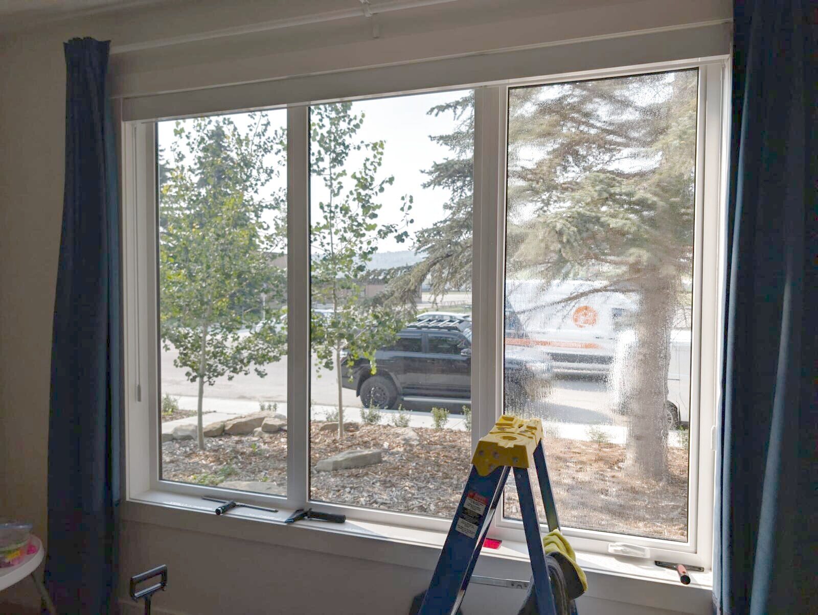 Dual-reflective DR 37 window film freshly applied to a street-facing living room window in Bowness, NW Calgary