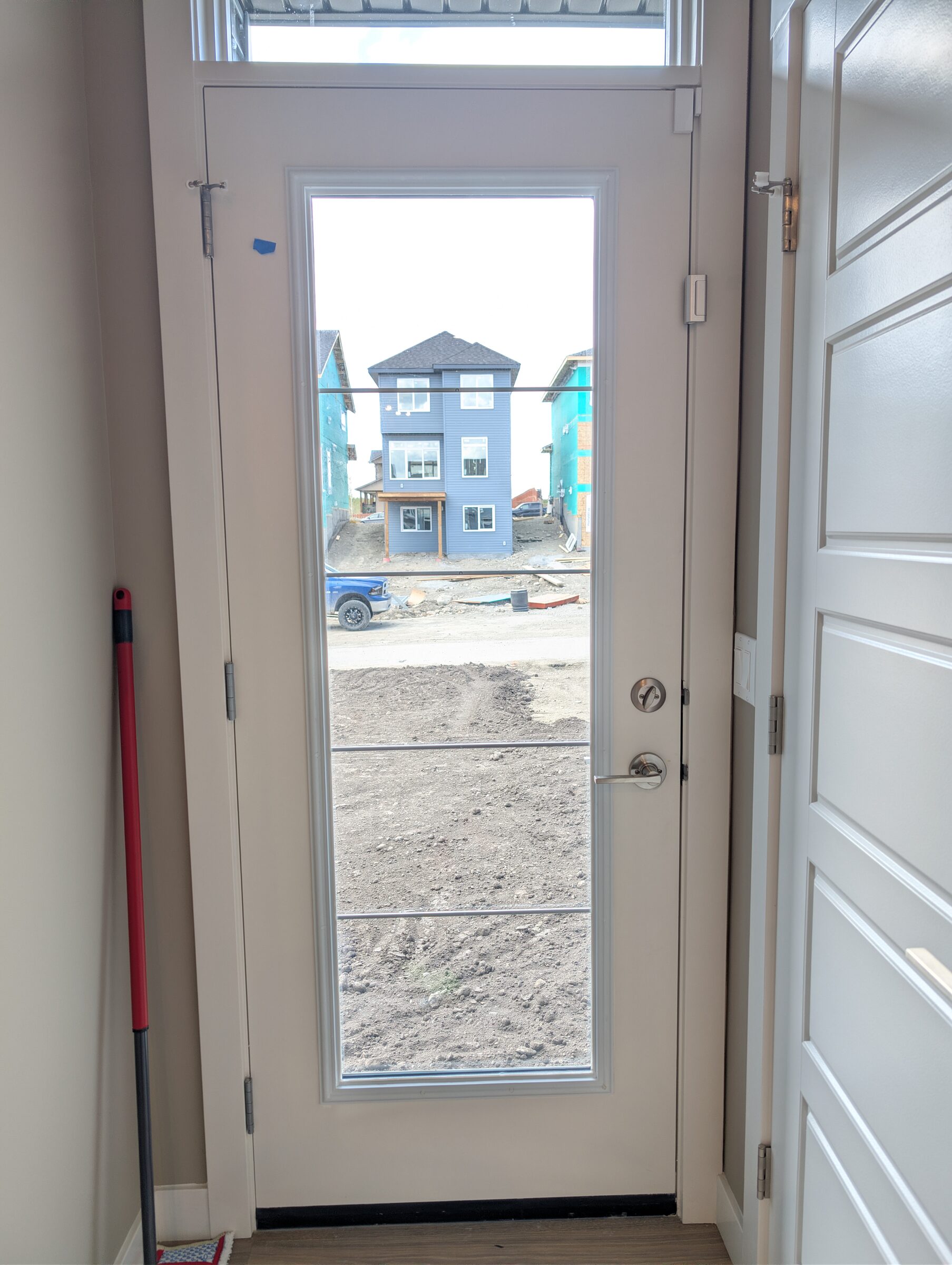 Front entry door glazing protected with 8 mil safety and security window film in a Cochrane new-build home