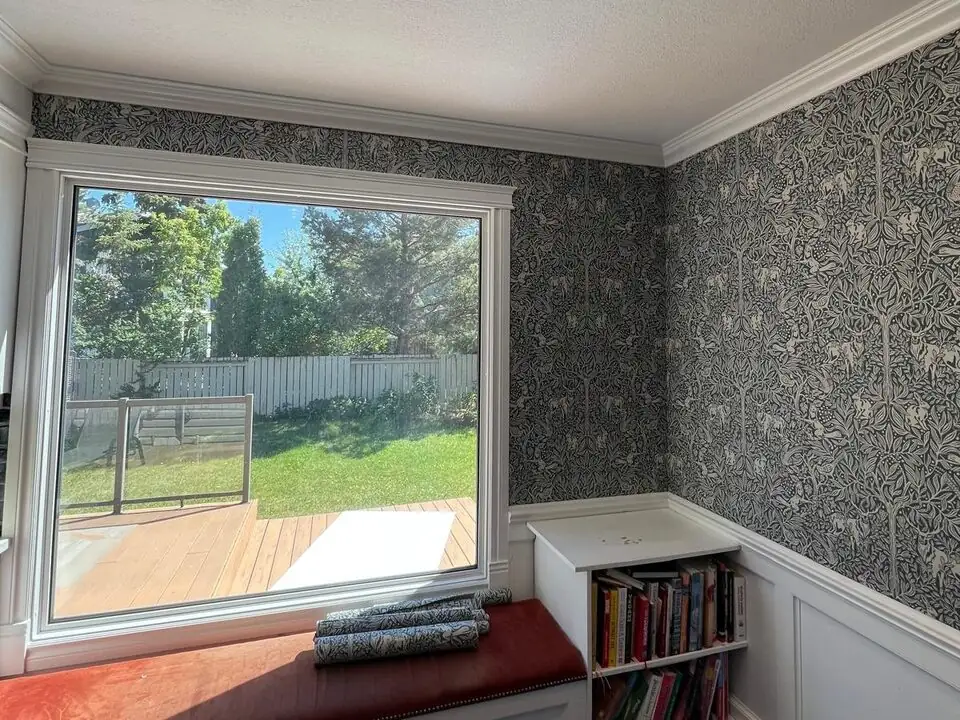 Blue botanical wallpaper installed around a dining room window in Deer Run SE Calgary
