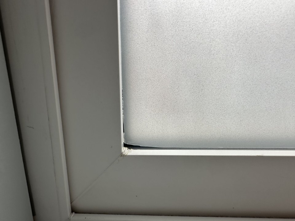 Close-up of a trimmed frosted window film edge at the frame