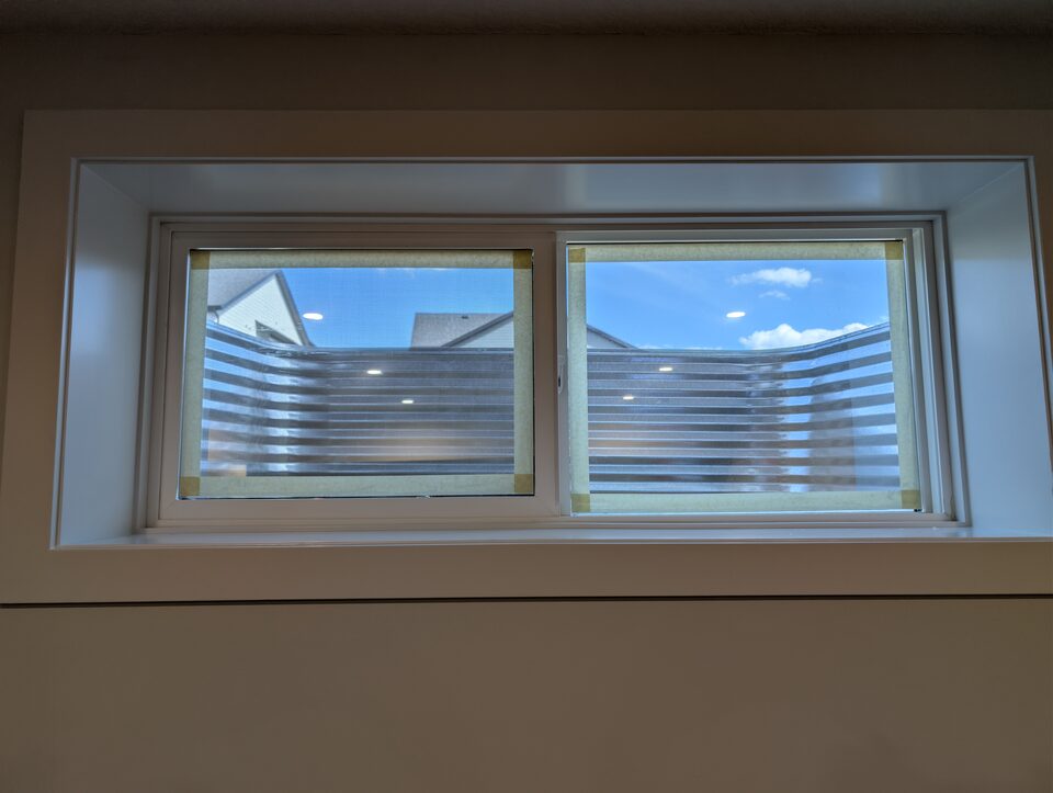 After wide interior photo of solar and security window film installed on a basement window in Harmony Rocky View County