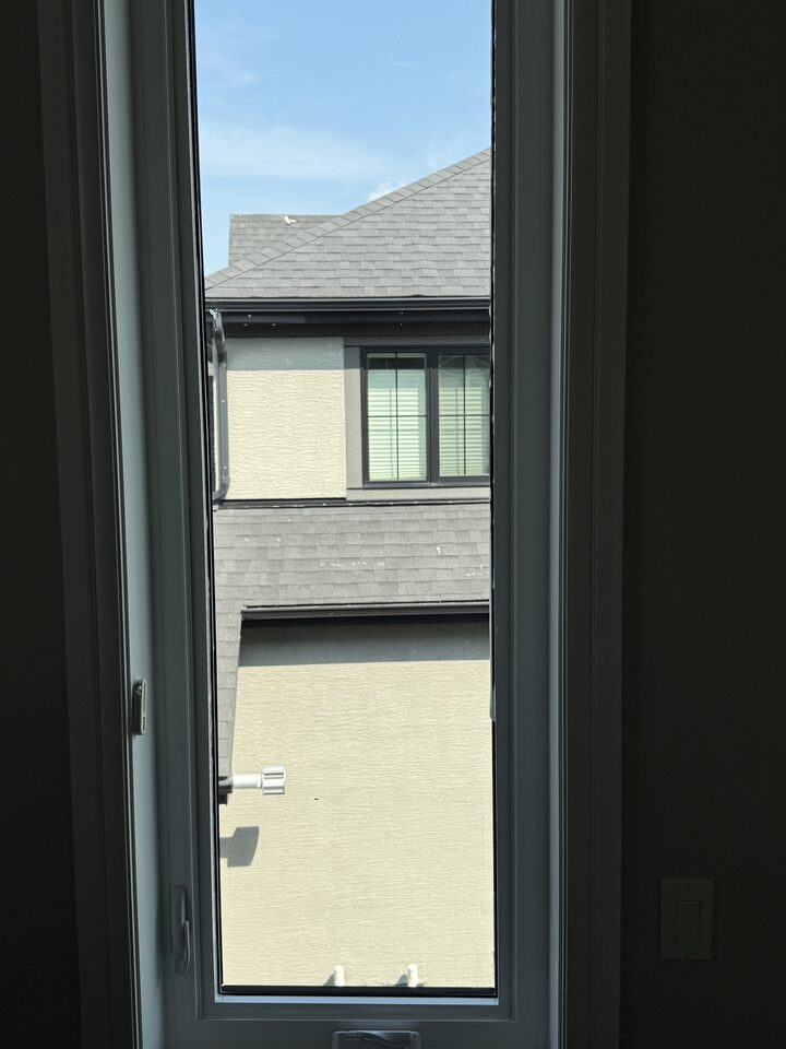 Interior view through a bedroom transom window with solar control film cutting glare in a Heritage Pointe home near Calgary