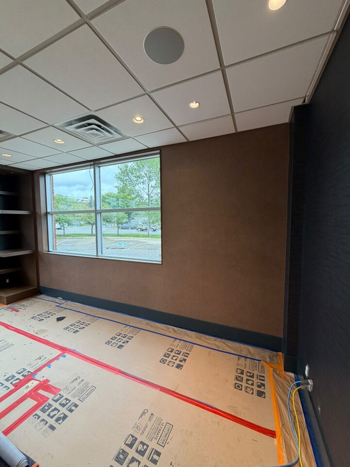 Front office with bronze textured commercial wallcovering around a street-facing window, Highfield, SE Calgary