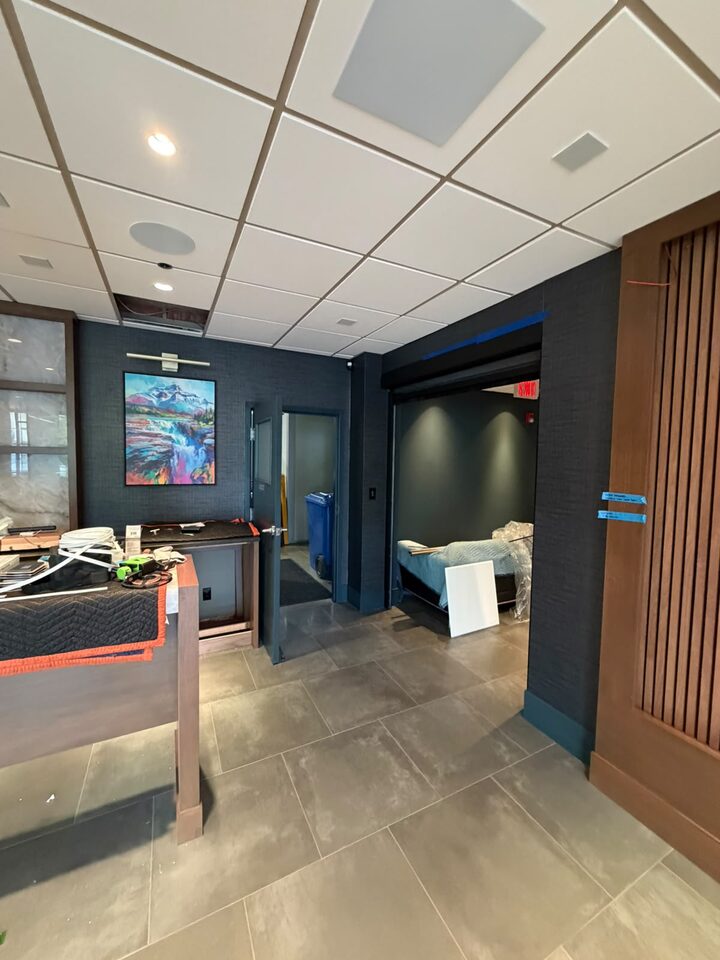 Reception desk area with charcoal commercial wallcovering meeting a wood slat wall, Highfield office, SE Calgary