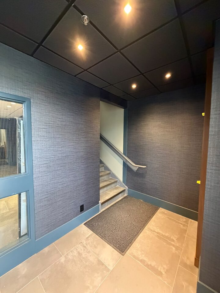 Commercial vinyl wallcovering wrapping the stair lobby walls of a Highfield SE Calgary office