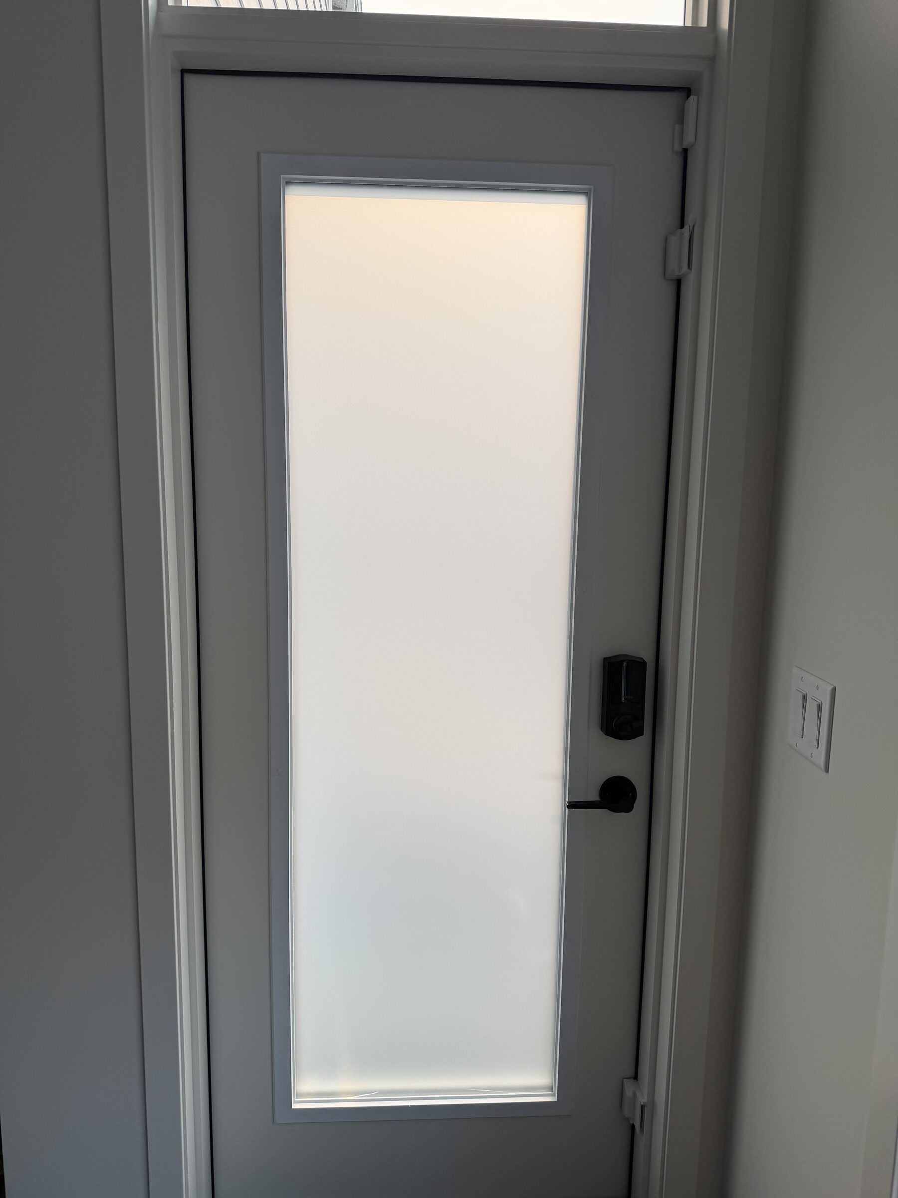 Silver Tech frosted privacy film on a high transom window in a new-build home in Mahogany, SE Calgary