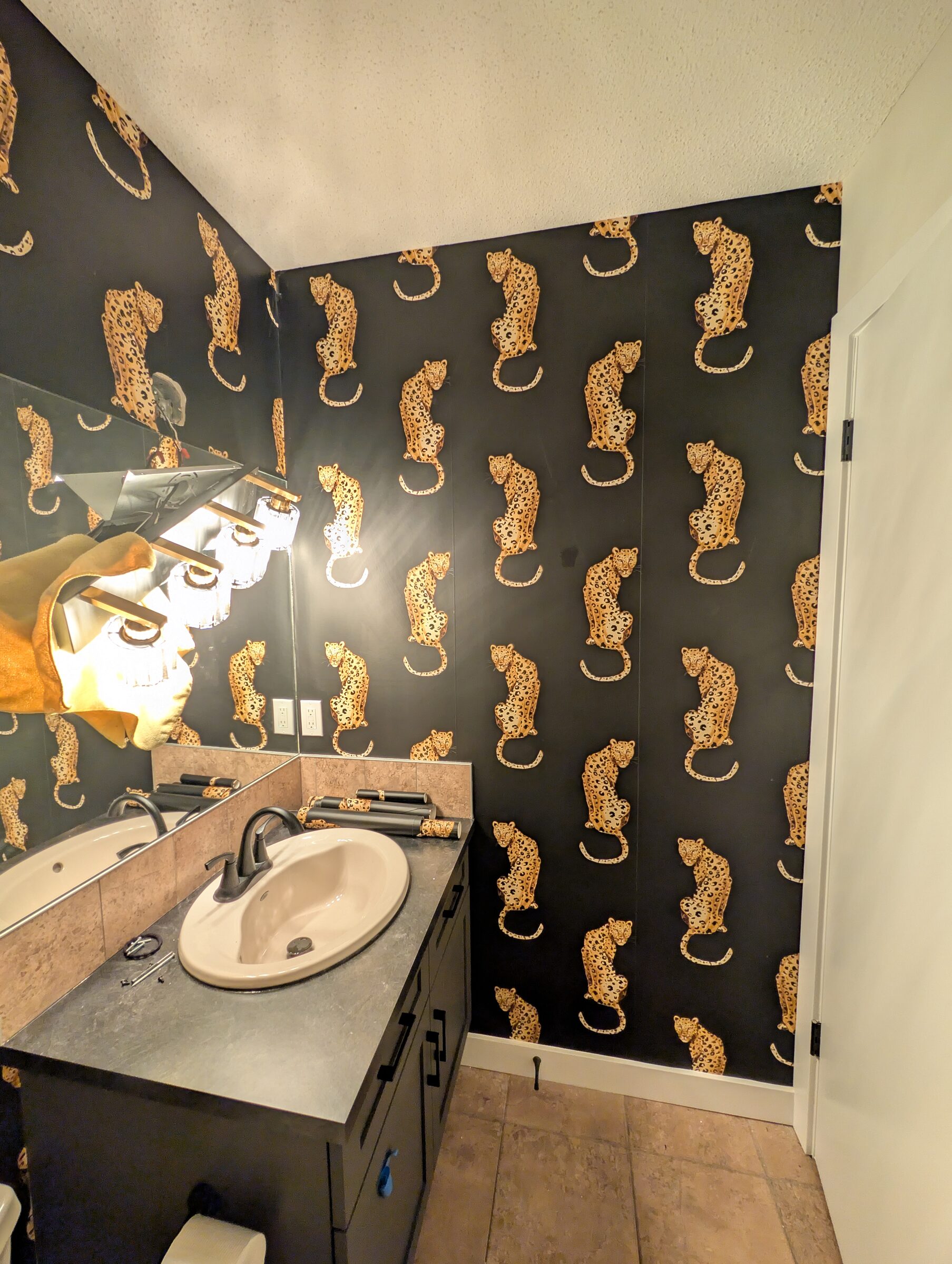 Peel-and-stick leopard wallpaper installed in a McKenzie Towne Calgary powder room