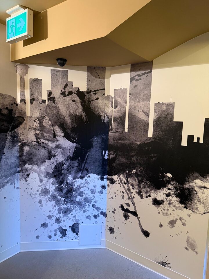 Calgary skyline mural wallcovering wrapped continuously around an inside corridor corner beside a doorway, commercial installation in downtown Calgary