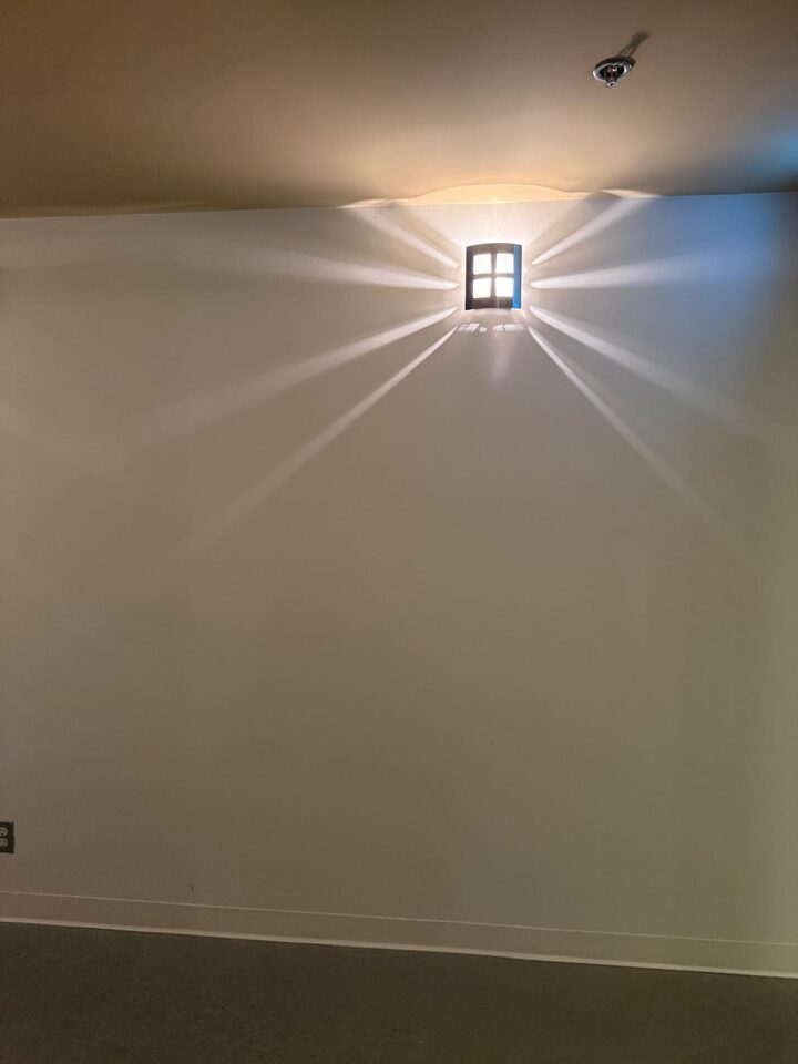 Blank painted corridor wall under a wall sconce before custom mural wallcovering installation, Stephen Avenue, downtown Calgary