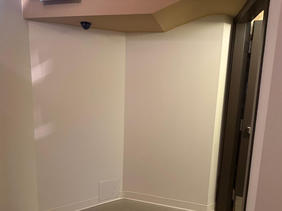 Corridor corner and doorway with bare walls before the skyline mural wallcovering was installed, downtown Calgary commercial building