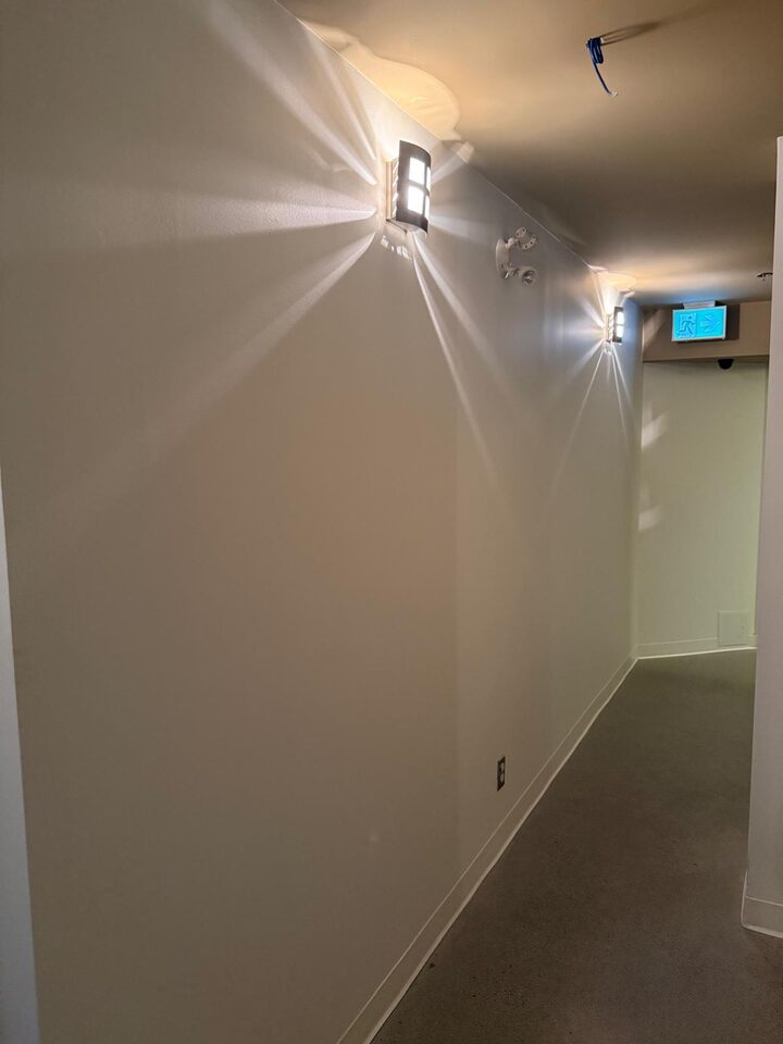 Full length of a commercial corridor with plain walls before mural wallcovering installation on Stephen Avenue, Calgary